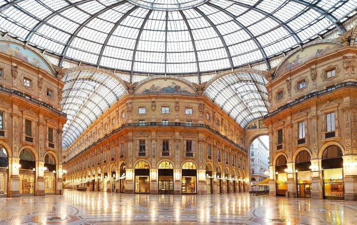 Innenansicht der Galleria Vittorio Emanuele II in Mailand mit Glasdach und historischen Fassaden.