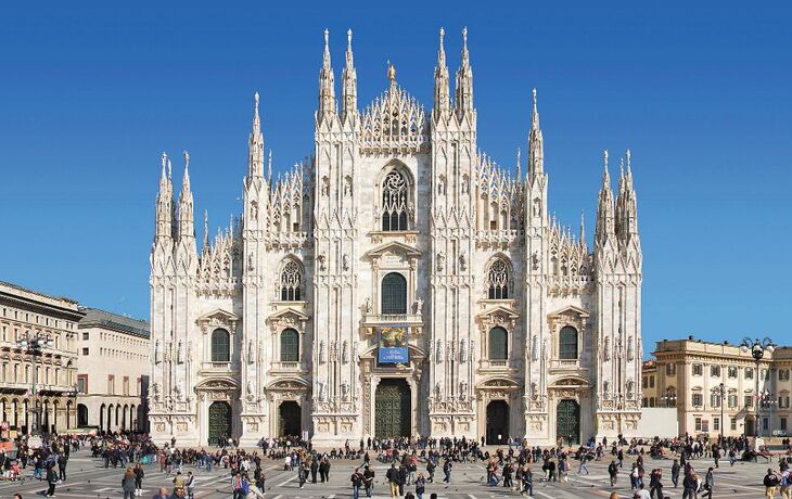 Mailänder Dom und Umgebung mit vielen Menschen auf dem Platz unter klarem blauen Himmel.