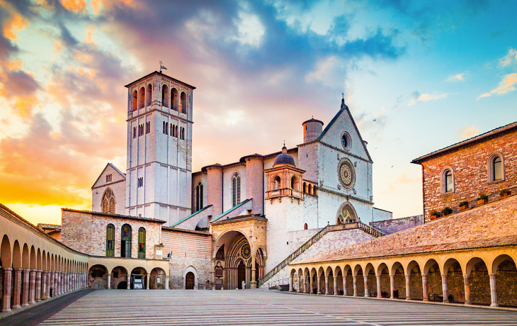 Basilika von San Francesco d'Assisi mit buntem Himmel im Hintergrund