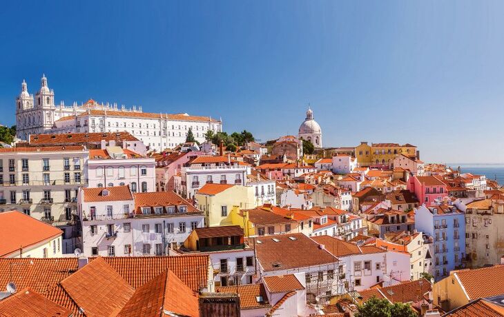 Panoramablick auf historische Altstadt mit roten Dächern und Kirche am Meer.