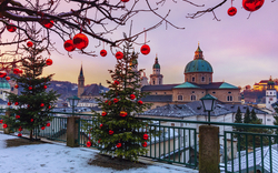 Winterlandschaft mit Weihnachtsbäumen und Kirche im Hintergrund.