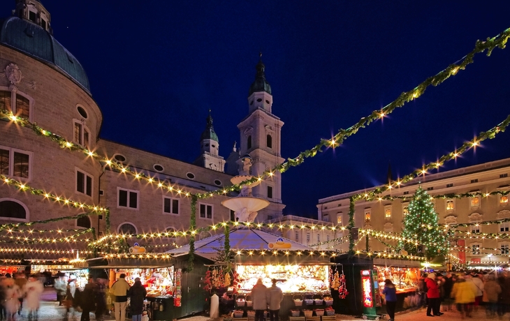 Weihnachtsmarkt bei Nacht mit beleuchteten Ständen und Dekoration.