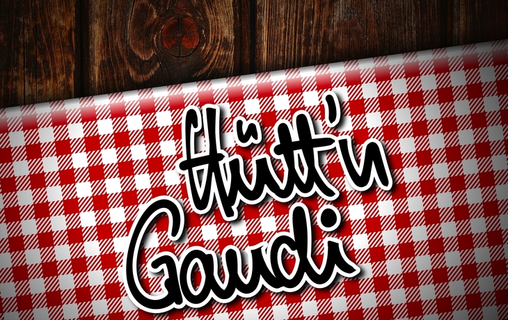 Holzhintergrund mit rot-weiß kariertem Textil und Schriftzug "Hütt'n Gaudi".