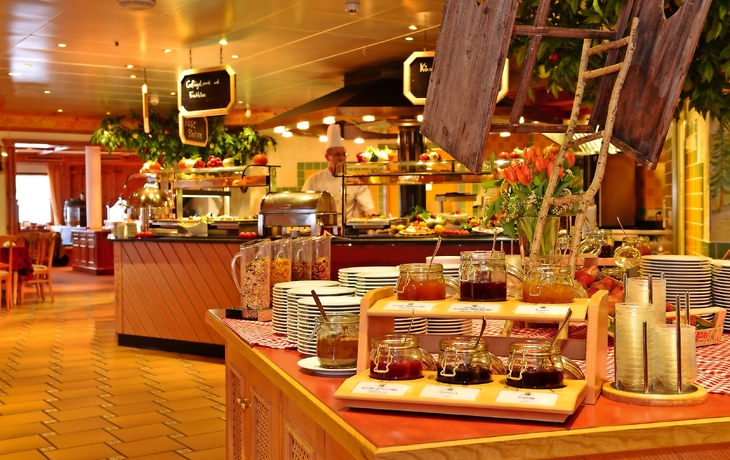 Frühstücksbuffet mit verschiedenen Speisen und Konfitüren in einem Restaurant.