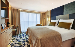 Moderner Kabinenbalkon mit Bett, Schreibtisch und Fenster auf einem Kreuzfahrtschiff