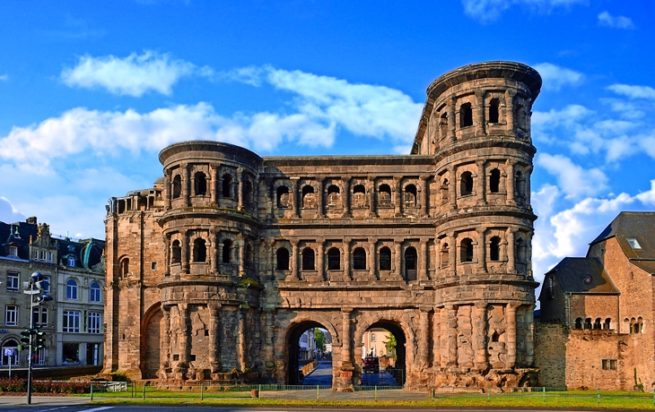 Römisches Stadttor vor blauem Himmel, historische Architektur.