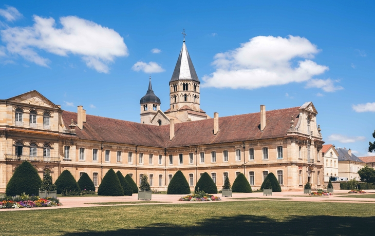 Alte Abtei mit Türmen und blauen Himmel im Hintergrund.