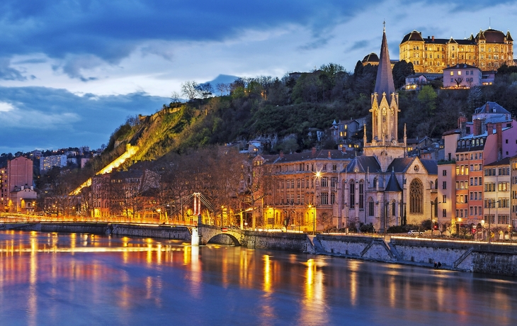 Lyon bei Nacht, beleuchtete Gebäude und Flussufer im Abendlicht