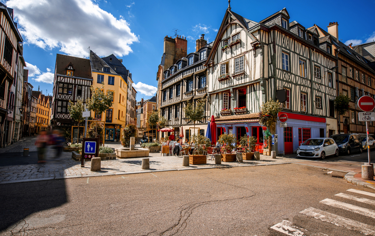 Historische Fachwerkhäuser an sonnigem Platz in einer europäischen Stadt.